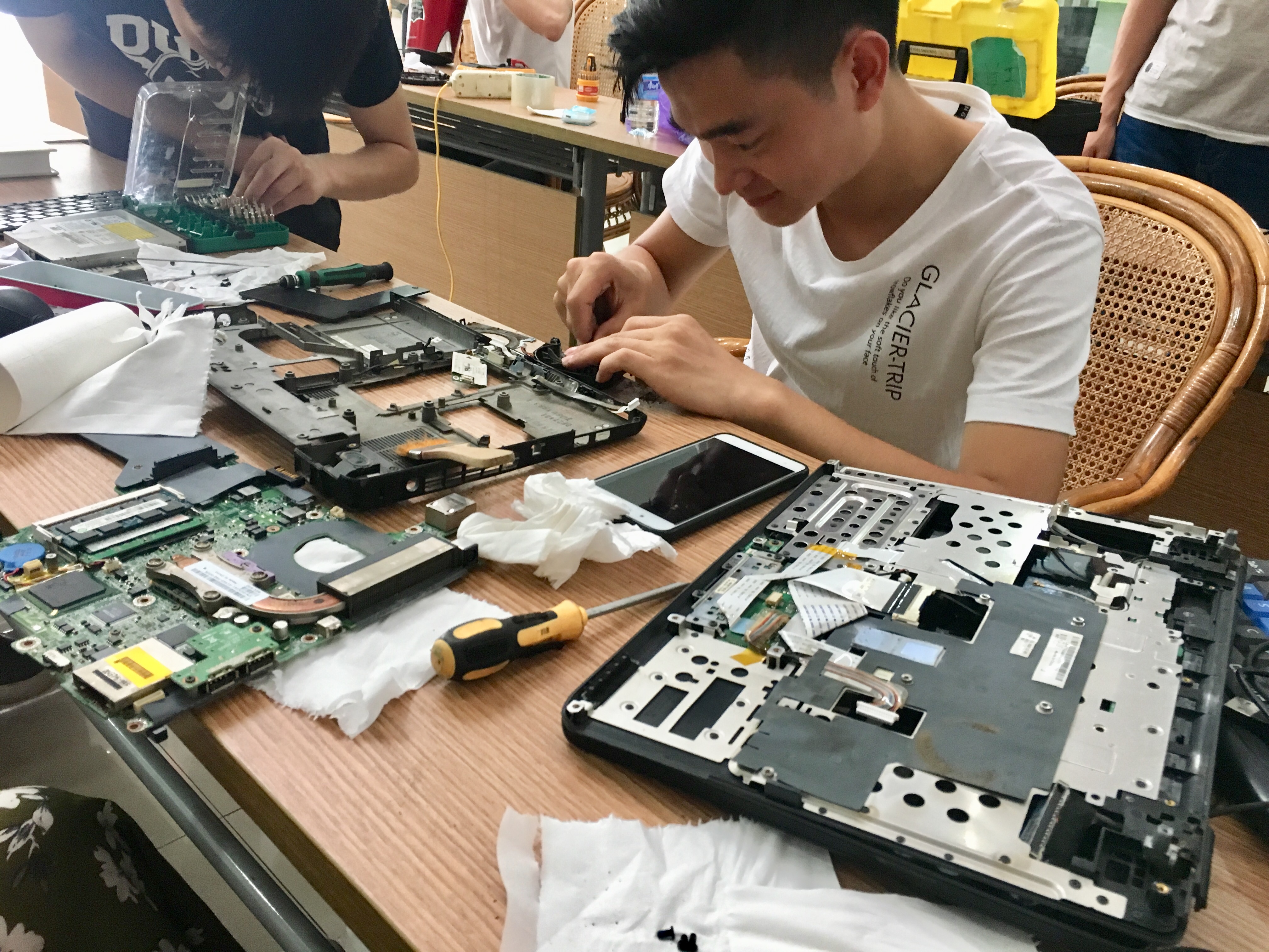 图为团队成员为陈旧电脑清灰 通讯员 李怡 摄